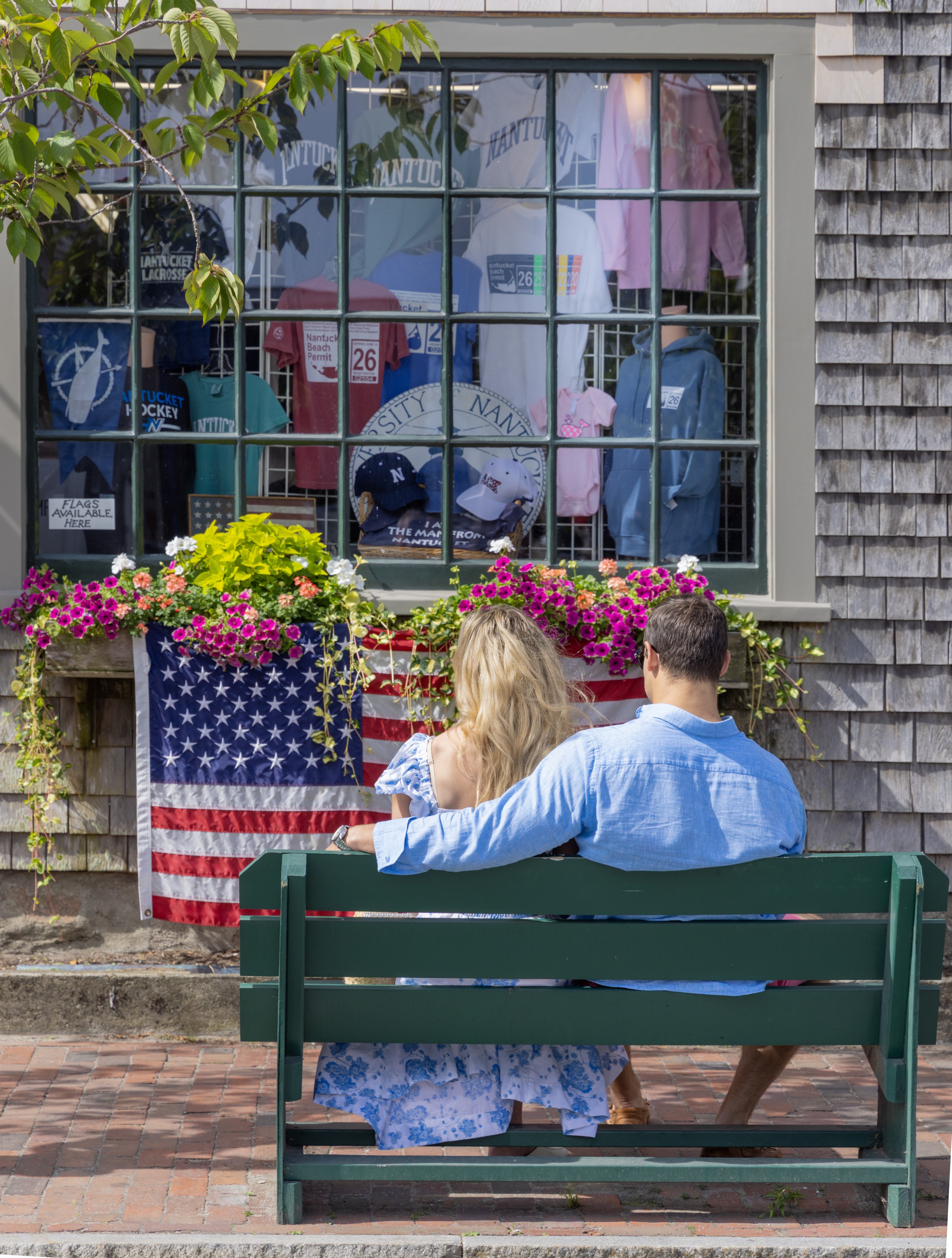Couple sitting on a bench in front of a store in downtown Nantucket