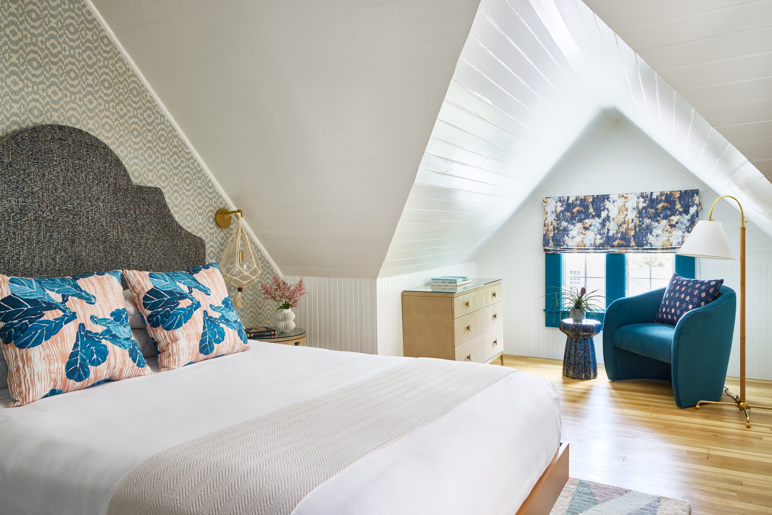 Queen guest room with sitting area that has a comfortable teal chair