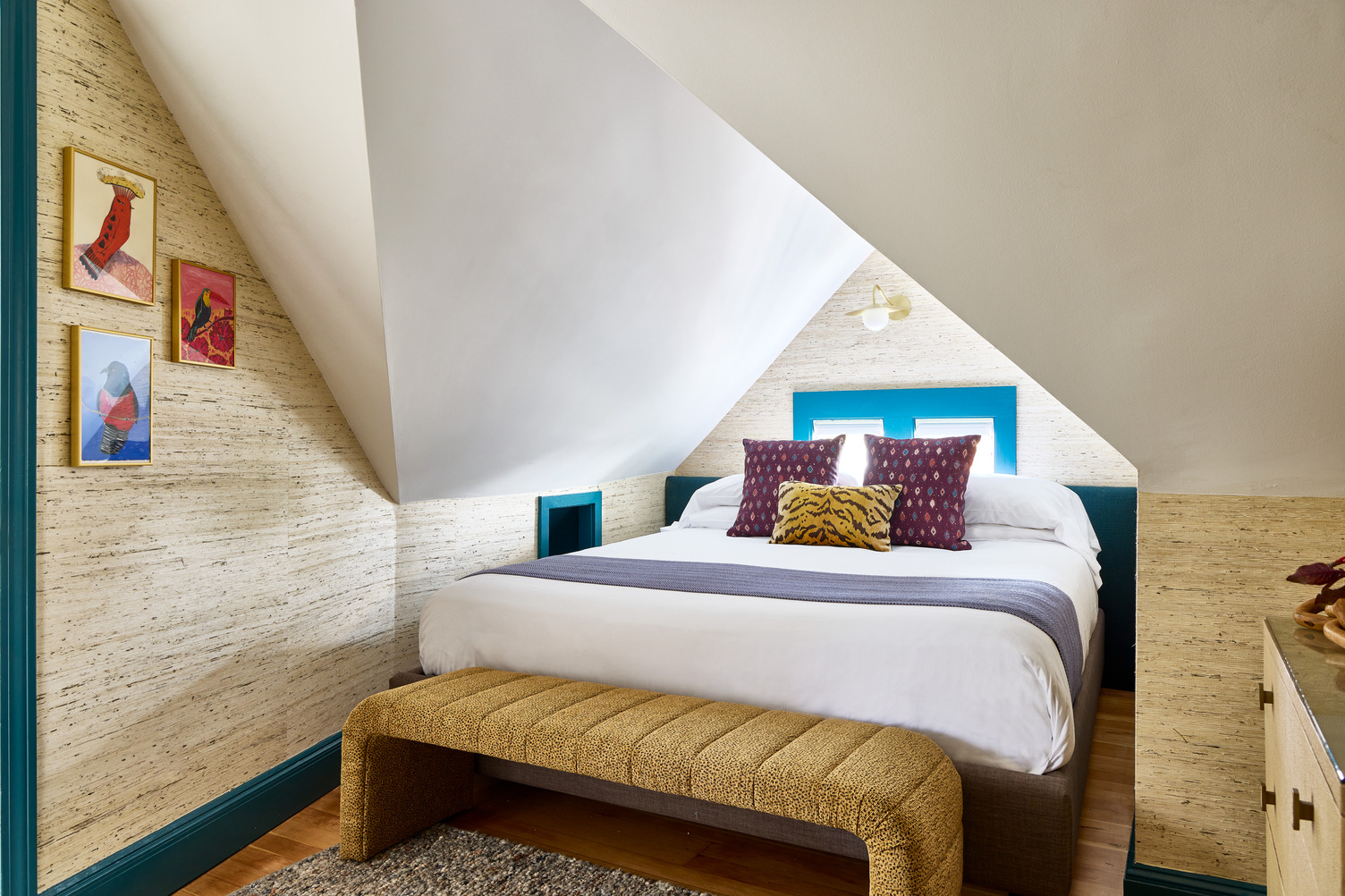 Queen guest room with a comfortable queen bed and a yellow bench at the foot of the bed