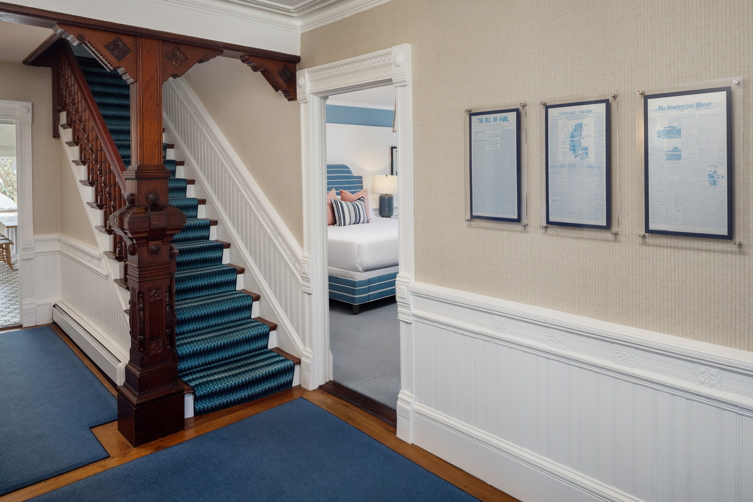 First floor hallway of 76 Main Ink Press Hotel with prints on the wall and an open guestroom